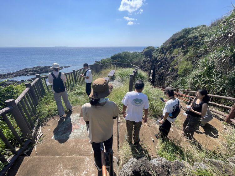 ヤヒジャ海岸へ続く遊歩道の階段を下りるツアー参加者