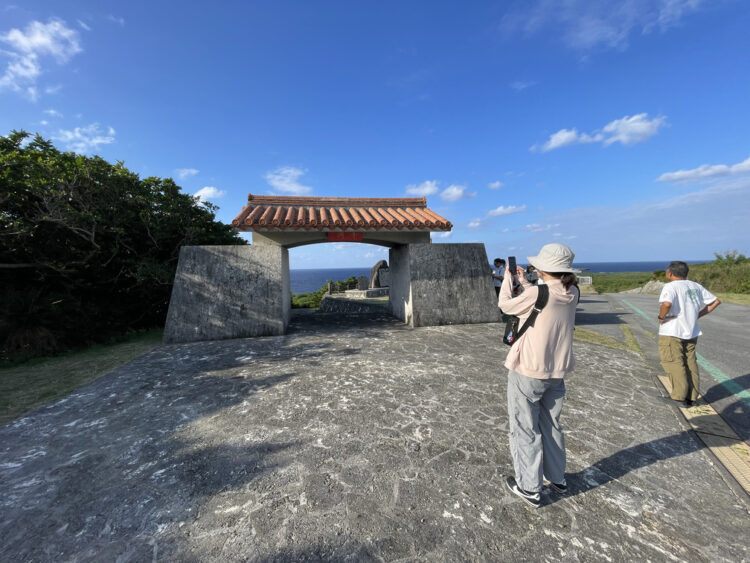 粟国島の鍾乳洞「洞寺」の赤瓦の門と海